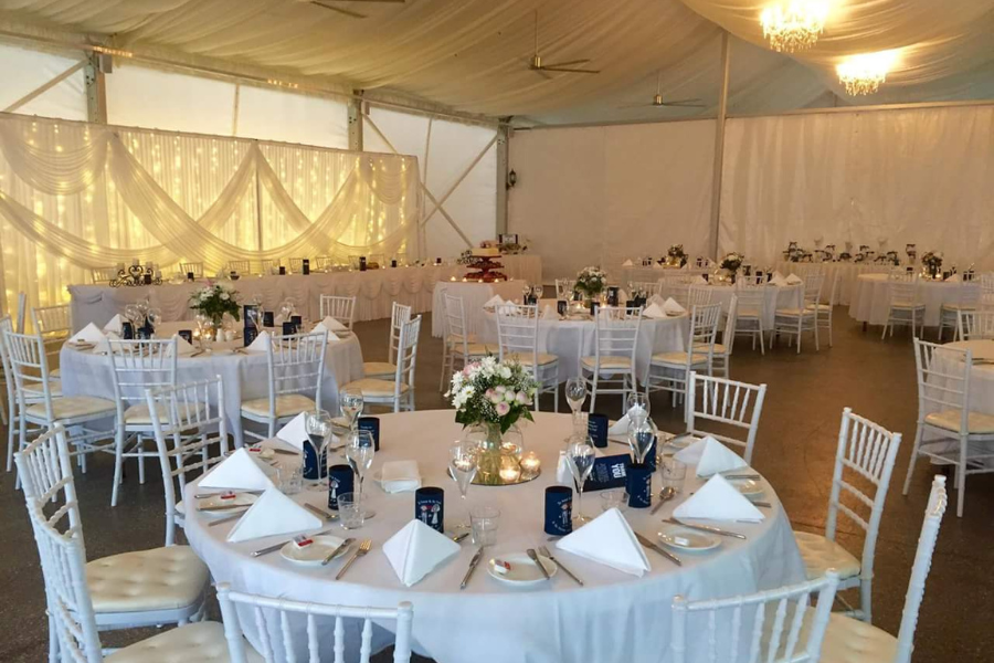 Reception tables inside the Marquee with a fairy light backdrop